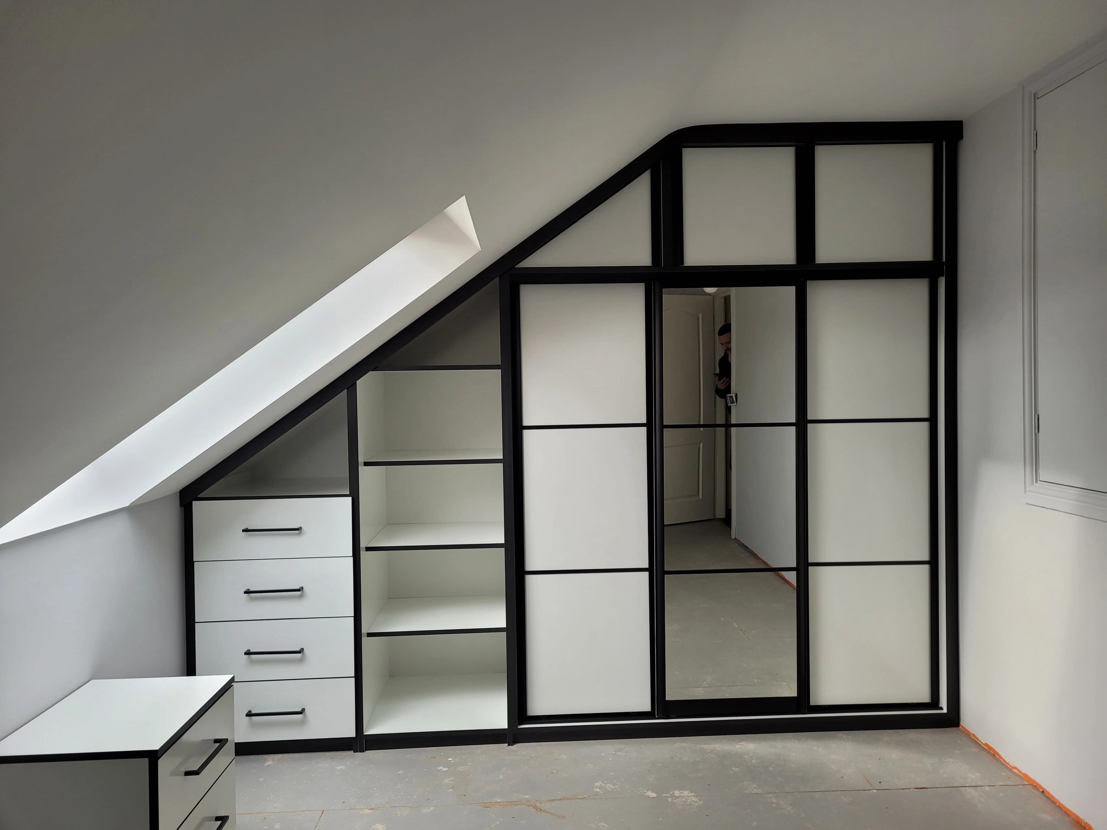 Industrial style loft wardrobe with black grid frame and angled ceiling fit