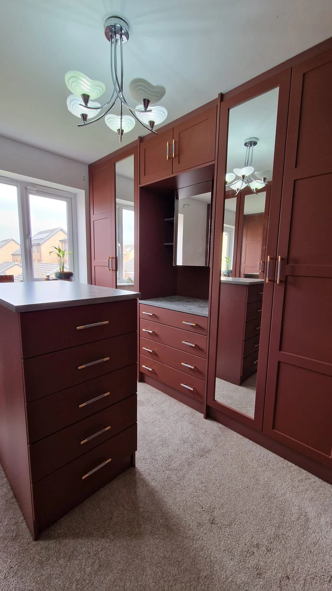 Full dressing room with island and vanity in terracotta finish