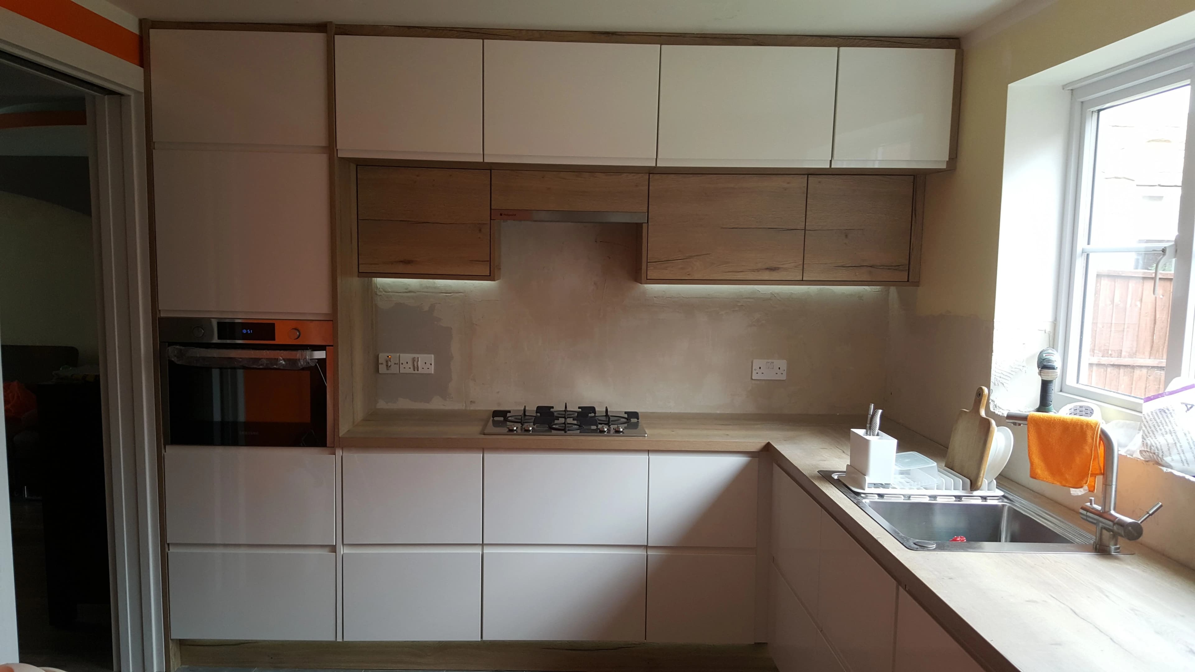 High gloss white kitchen with wood grain feature units
