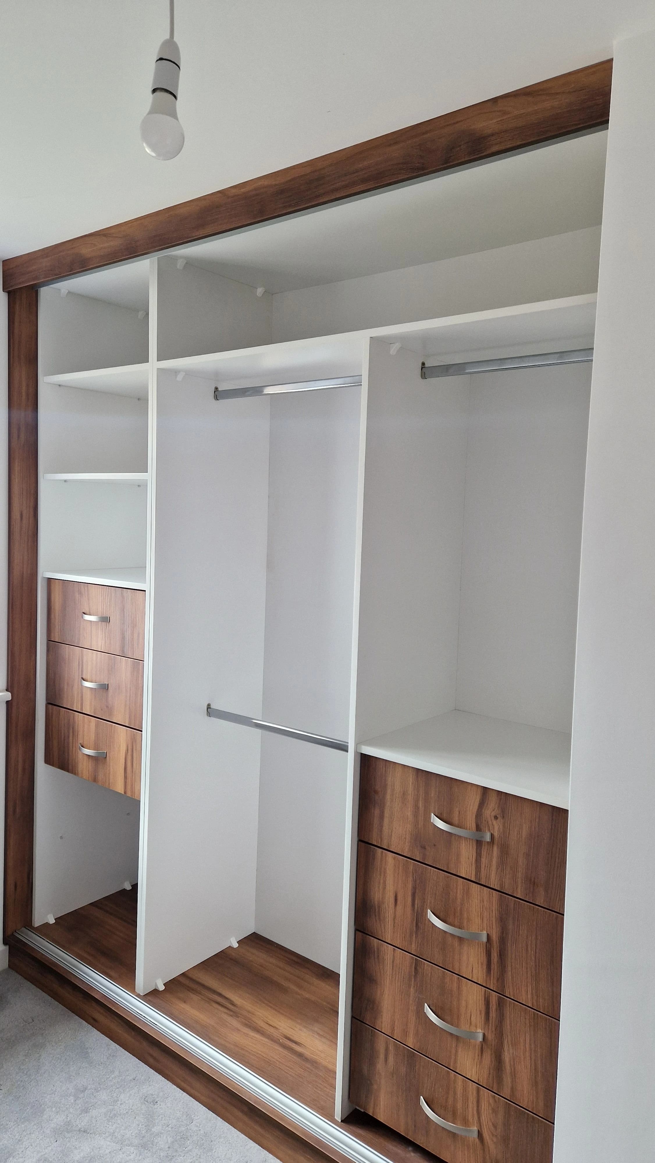 Wardrobe interior with walnut drawers and white shelving