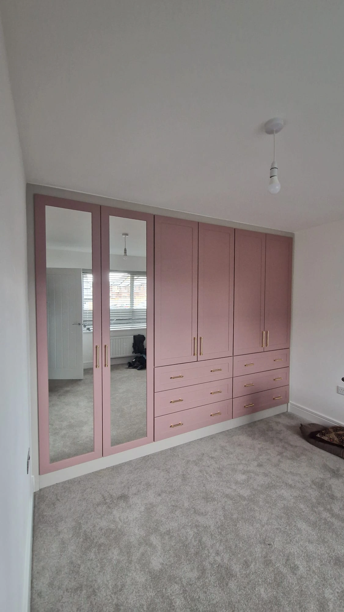 Pink shaker style wardrobe with brass handles and mirrored doors