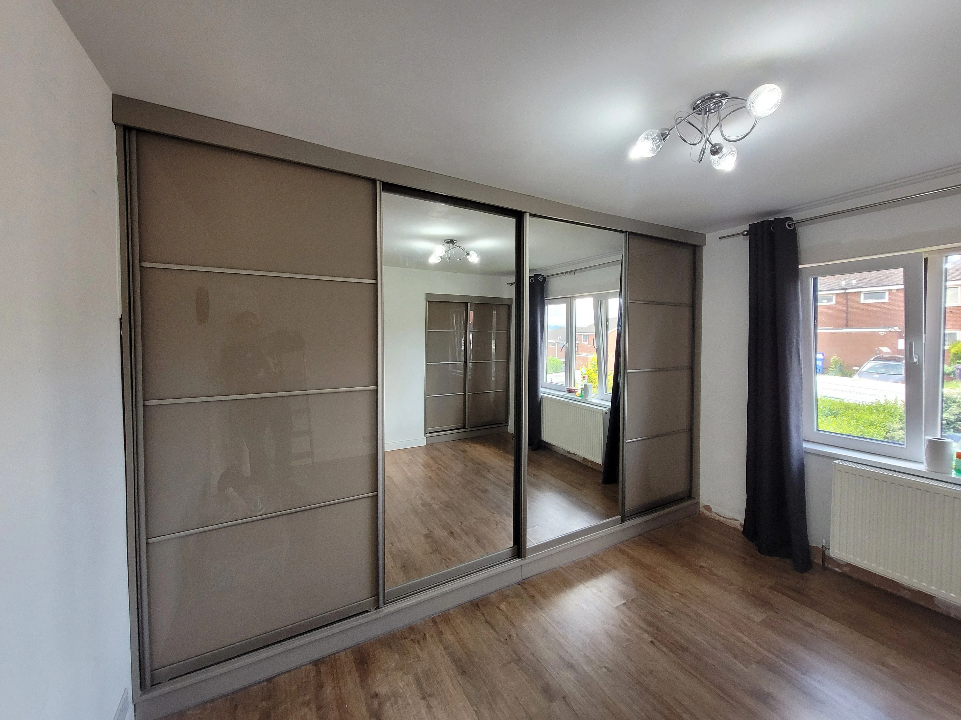 High gloss sliding wardrobe with central mirror