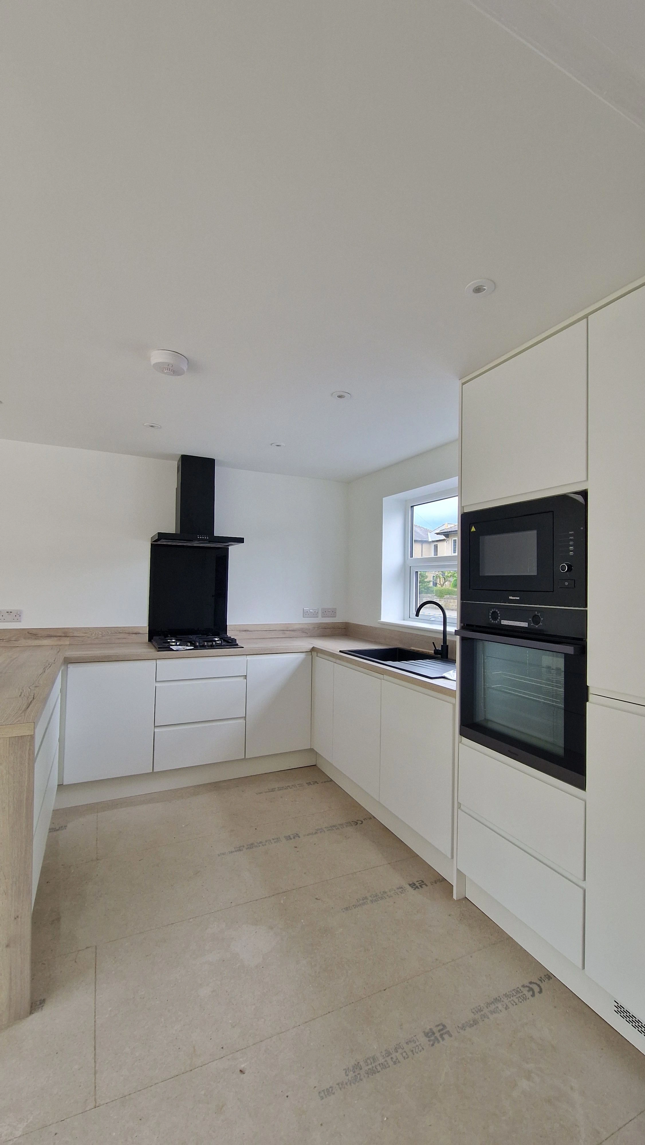 Minimalist white handleless kitchen with black sink